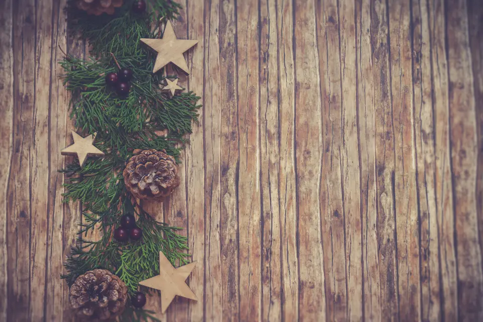 Rustic barn wood boards decorated with evergreen garland, pinecones and wooden stars