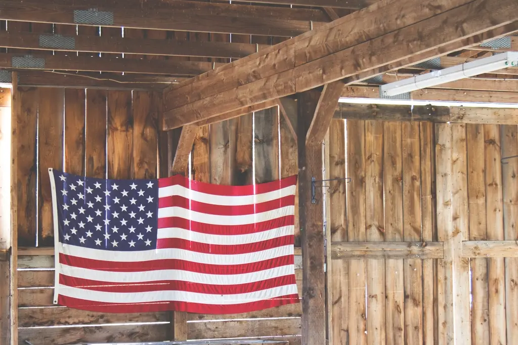 American flag hanging on a rustic wooden barn wall