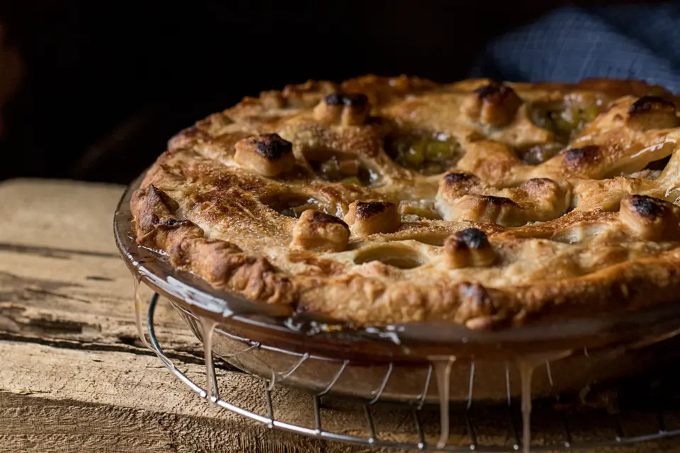 Golden homemade pie cooling on a wire rack