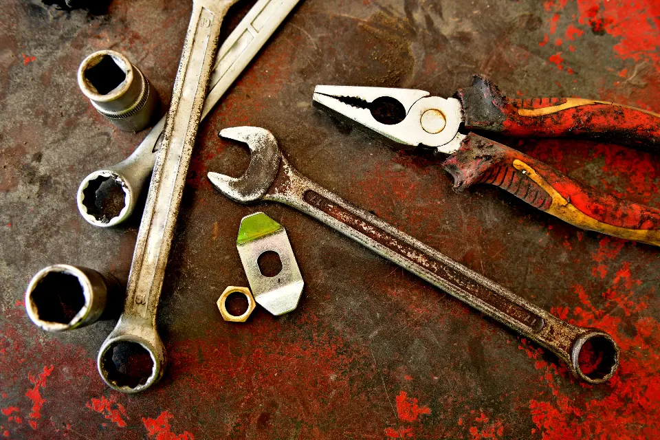 Rusty wrenches, sockets and pliers on corroded metal