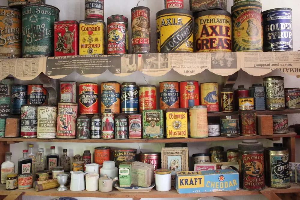 Shelves crowded with vintage kitchen and spice tins