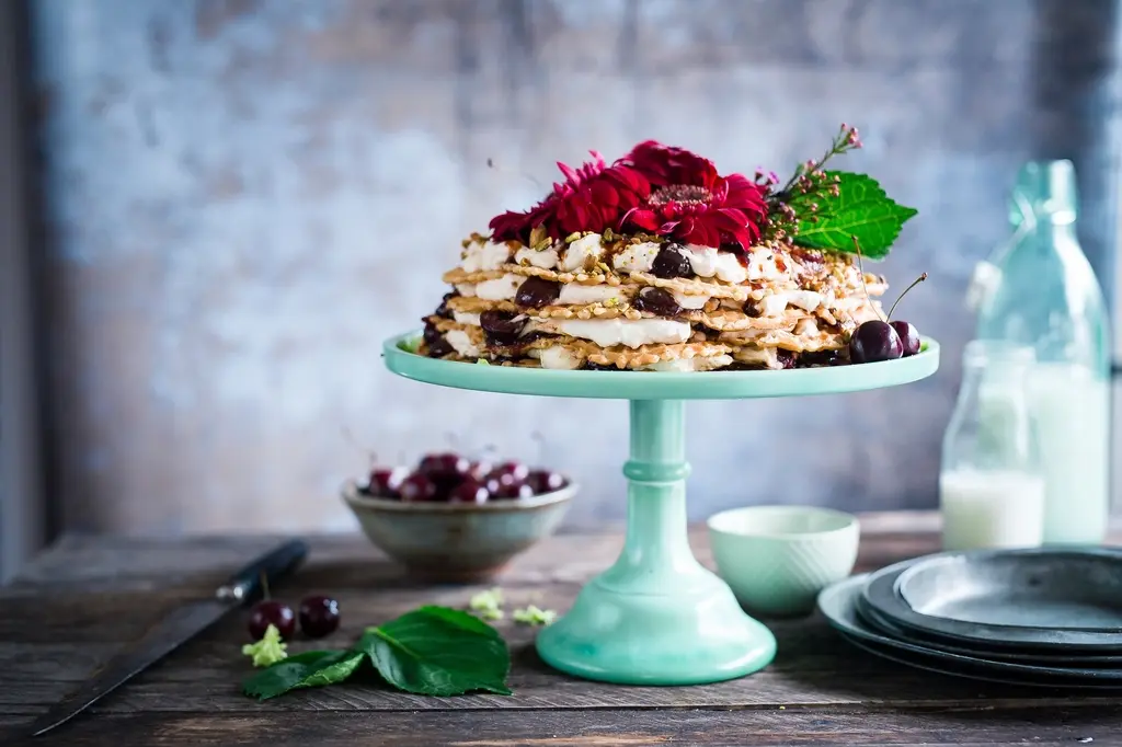 Styled vignette with a layered cake on a vintage mint-green cake stand