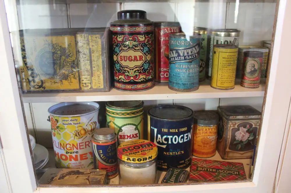 Glass-front cabinet filled with assorted vintage tins